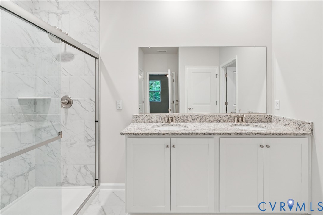 7784 Patriots Way Gloucester, VA 23061 - Photo 30 of 32 a bathroom with a granite countertop sink and a mirror