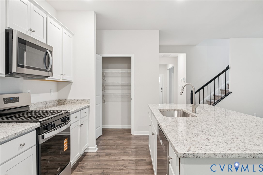 7784 Patriots Way Gloucester, VA 23061 - Photo 4 of 32 a kitchen with stainless steel appliances granite countertop a stove and a microwave