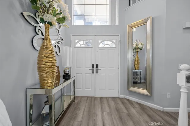 a kitchen with stainless steel appliances granite countertop a refrigerator a stove top oven a sink dishwasher and white cabinets with wooden floor