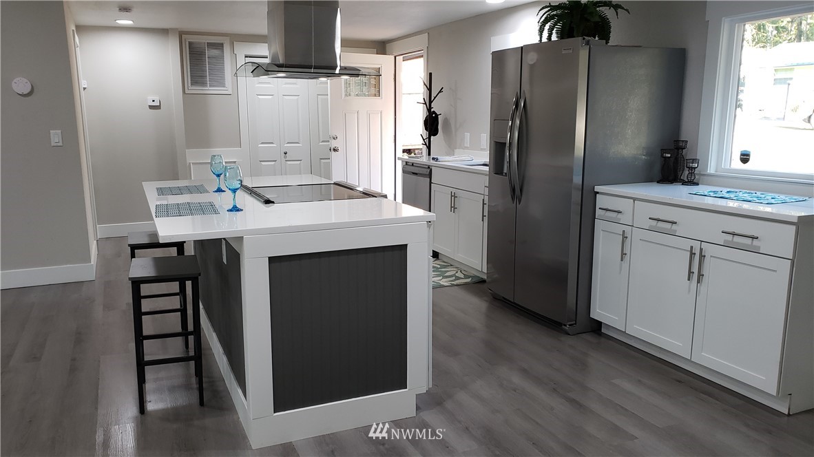 1040 Northeast Larson Boulevard Belfair, WA 98528 - Photo 6 of 31 a kitchen with kitchen island white cabinets and stainless steel appliances