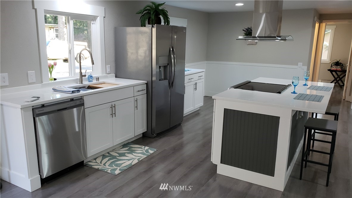 1040 Northeast Larson Boulevard Belfair, WA 98528 - Photo 7 of 31 a kitchen with stainless steel appliances granite countertop a sink stove and refrigerator