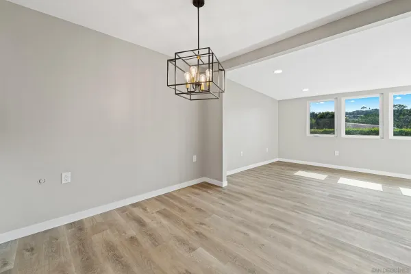 a view of empty room with wooden floor and window