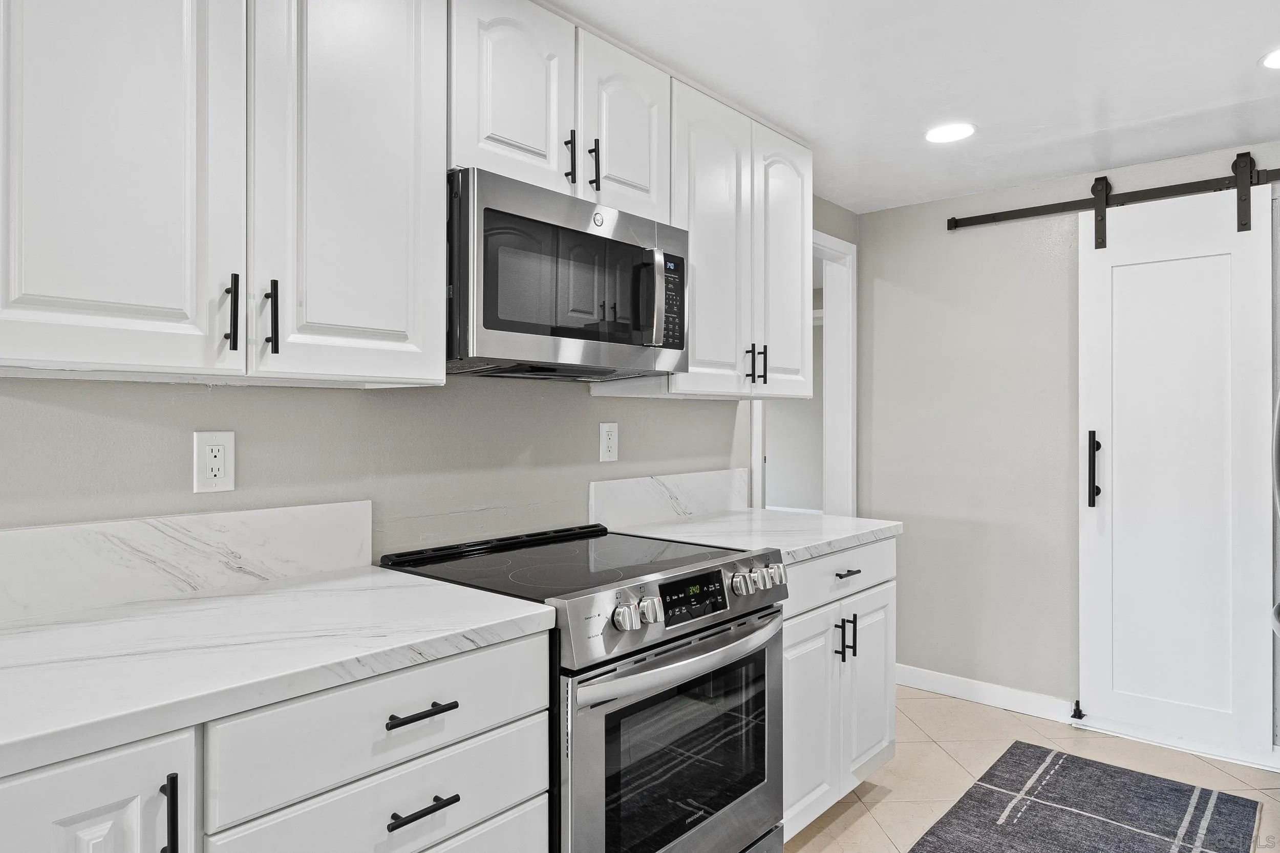 12424 Rios Road San Diego, CA 92128 - Photo 16 of 35 a kitchen with white cabinets and stainless steel appliances