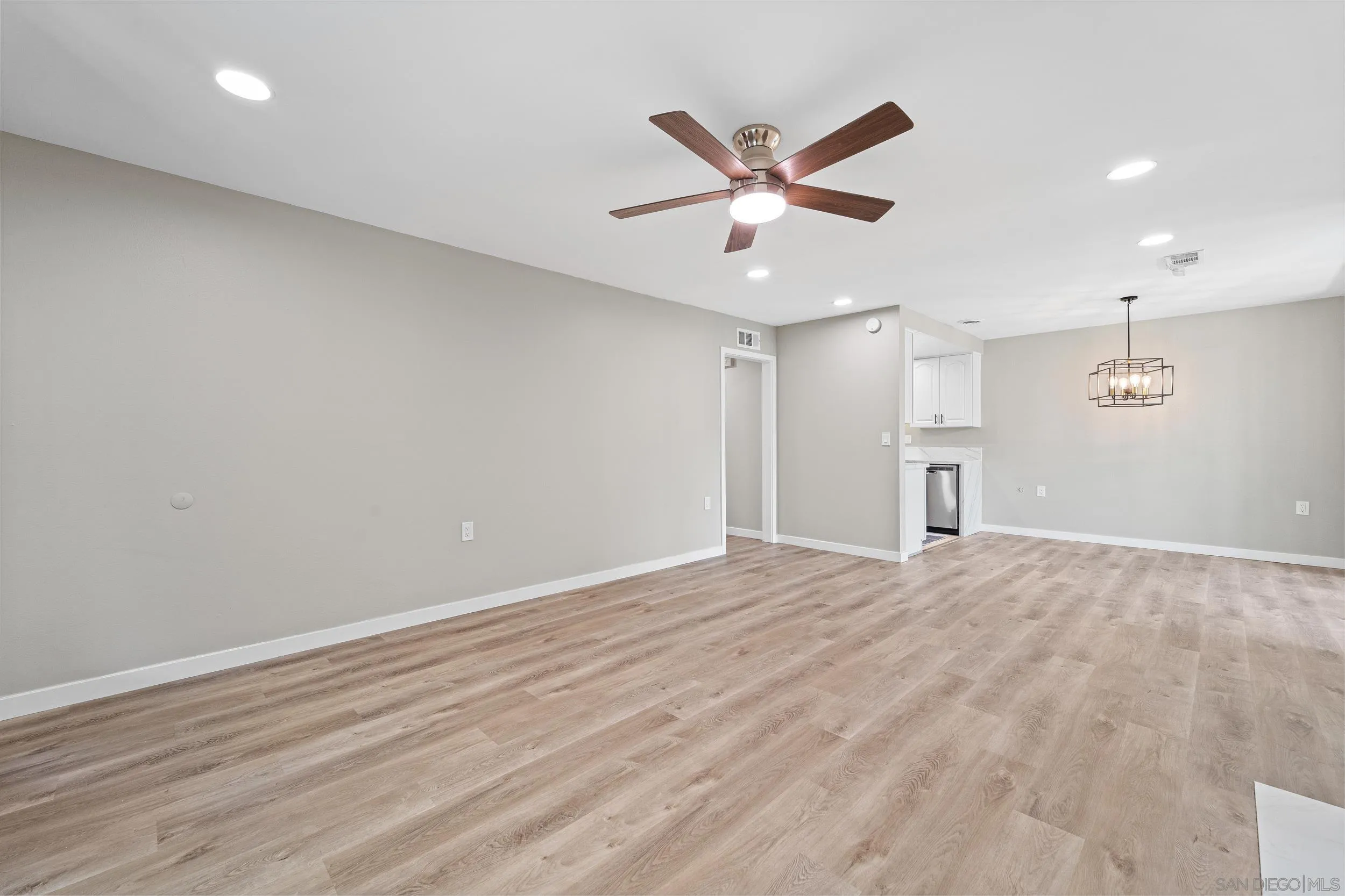 12424 Rios Road San Diego, CA 92128 - Photo 10 of 35 an empty room with wooden floor fan and windows