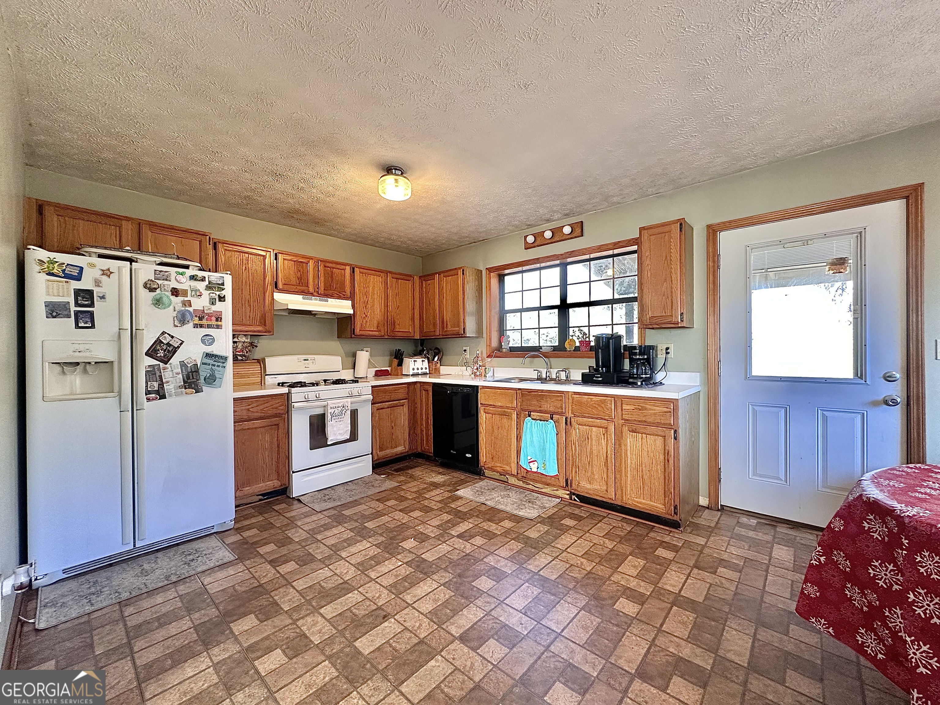 276 Oglesby Bridge Road Southeast Conyers, GA 30094 - Photo 30 of 49 a kitchen with stainless steel appliances granite countertop a refrigerator sink and cabinets