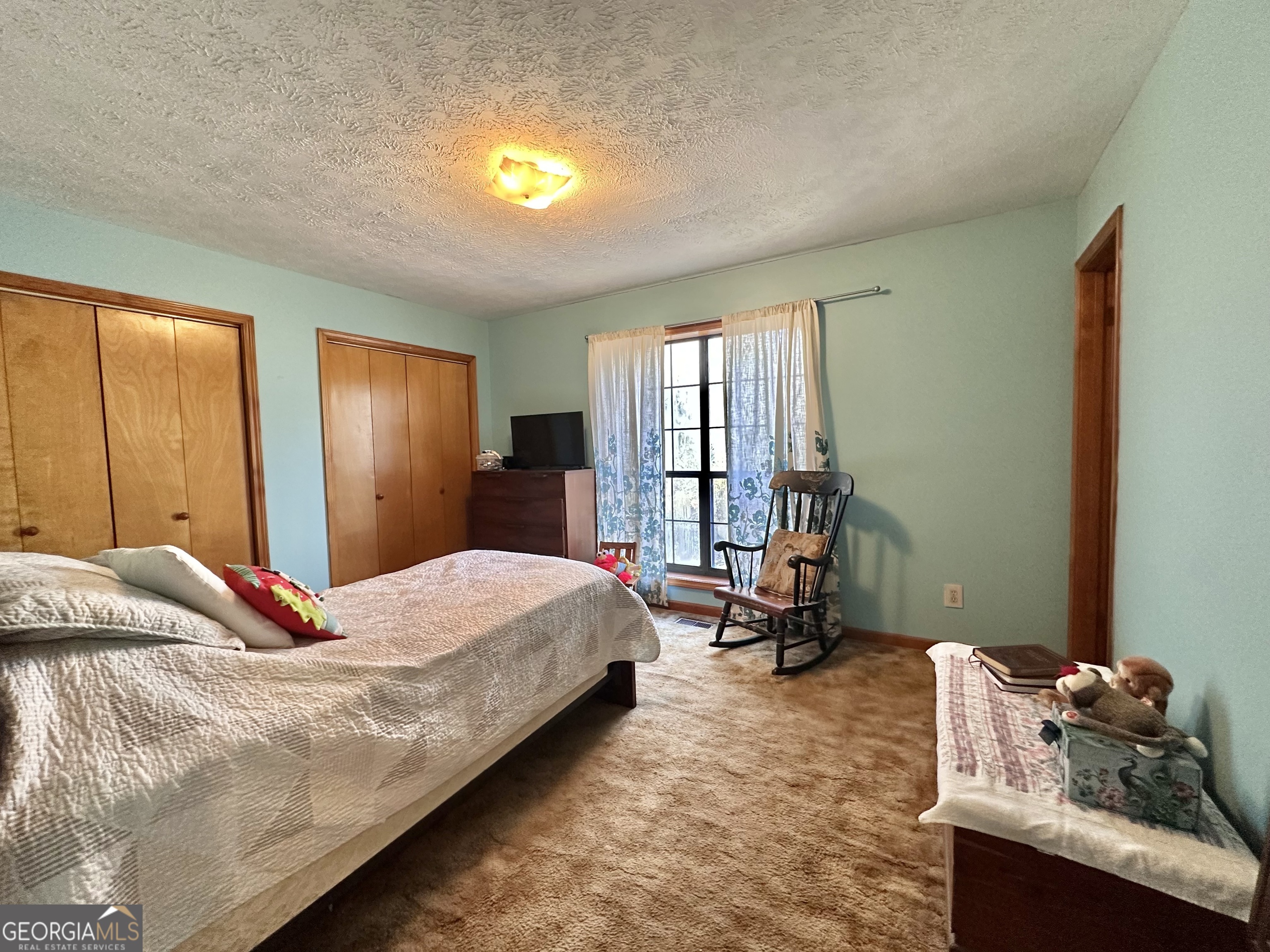 276 Oglesby Bridge Road Southeast Conyers, GA 30094 - Photo 41 of 49 a bedroom with a bed and large windows