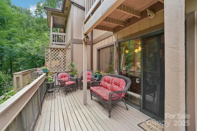 a balcony with wooden floor and outdoor seating
