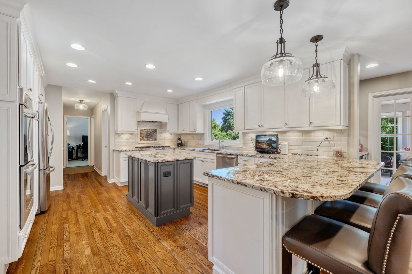 453 Brighton Drive Wheaton, IL 60189 - Photo 9 of 40 a kitchen with kitchen island granite countertop a table chairs refrigerator and microwave