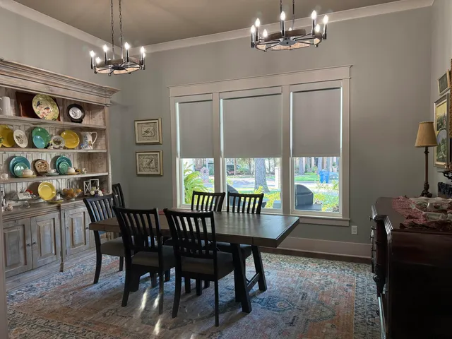 a view of a dining room with furniture a chandelier and window