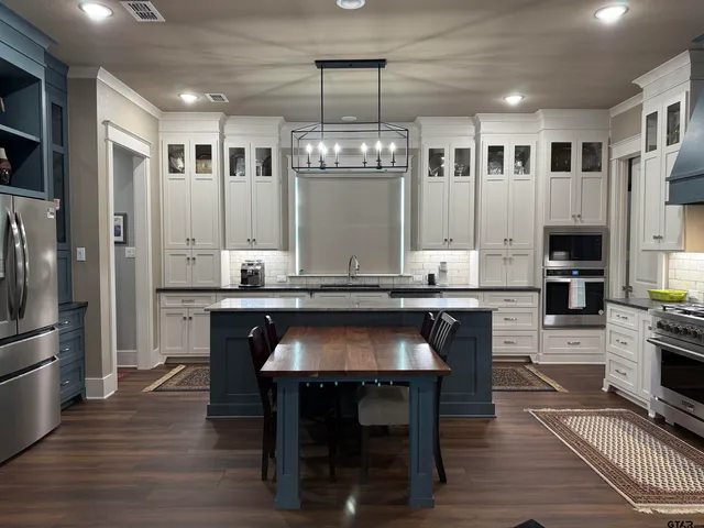 a kitchen with a refrigerator and a stove top oven