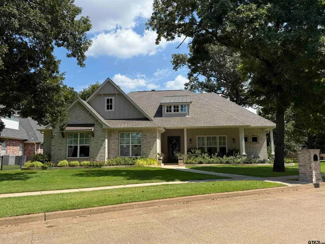 a view of a big house with a big yard and large trees
