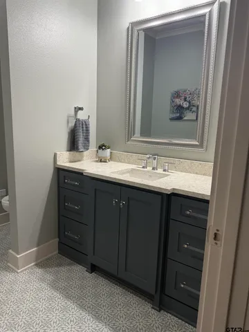 a bathroom with a sink vanity and mirror