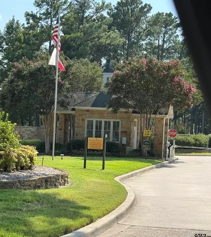 a house view with a garden space and wooden fence