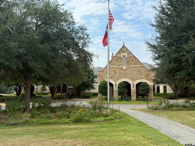 a front view of a house with a garden and trees
