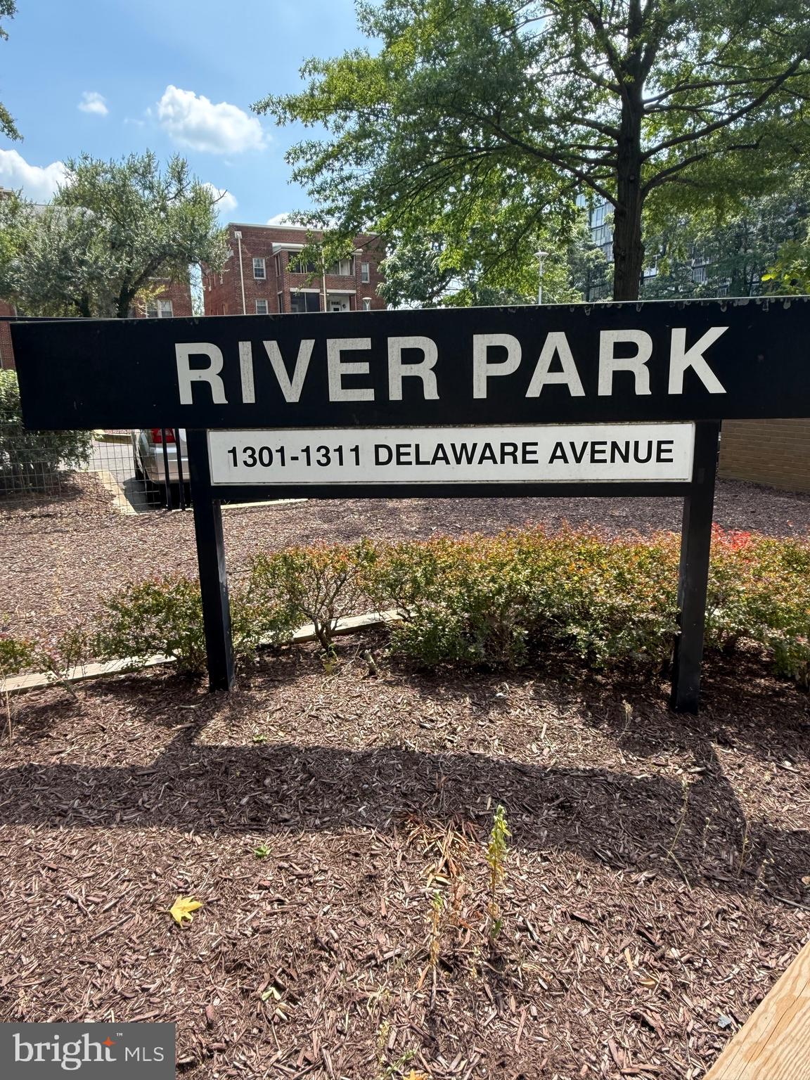 a view of a street sign under a large tree