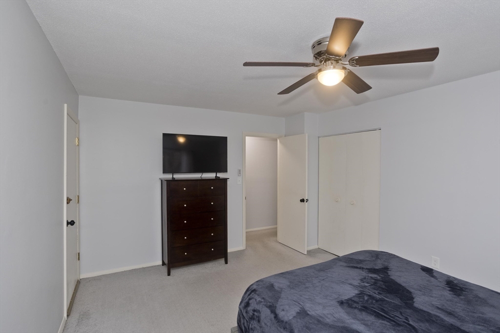 286 Nassau Drive, Unit 286 Springfield, MA 01129 - Photo 12 of 19 a bedroom with a bed and a ceiling fan
