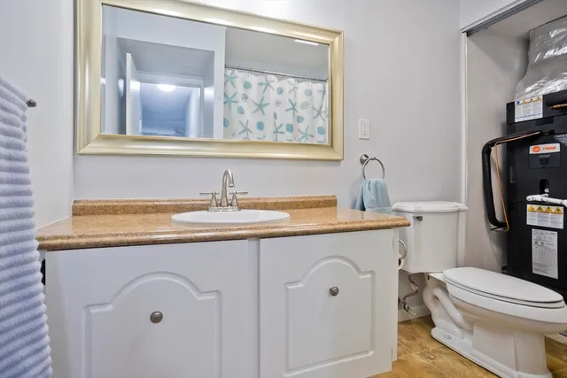 a bathroom with a granite countertop toilet sink and mirror
