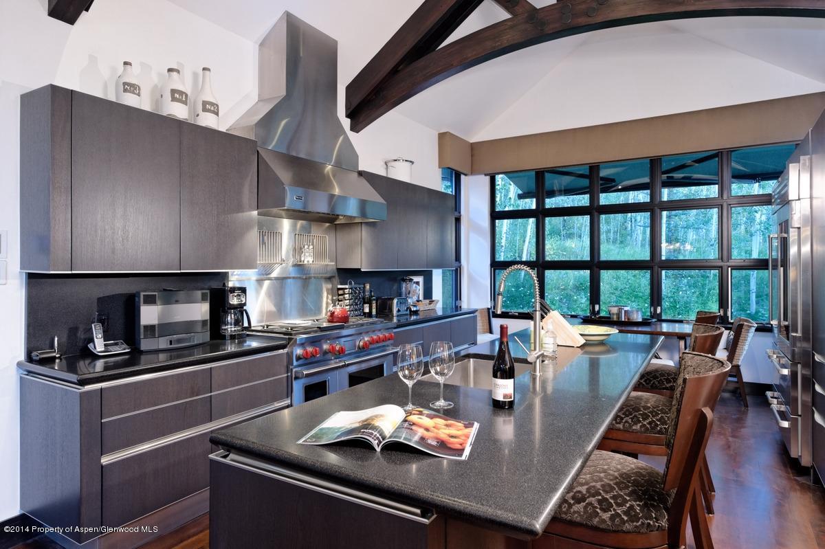 416 Moore Drive Aspen, CO 81611 - Photo 18 of 28 a kitchen with stainless steel appliances granite countertop a stove top oven a dining table and chairs with wooden floor