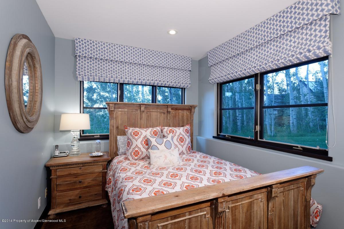416 Moore Drive Aspen, CO 81611 - Photo 24 of 28 a bedroom with a bed a mirror and a large window