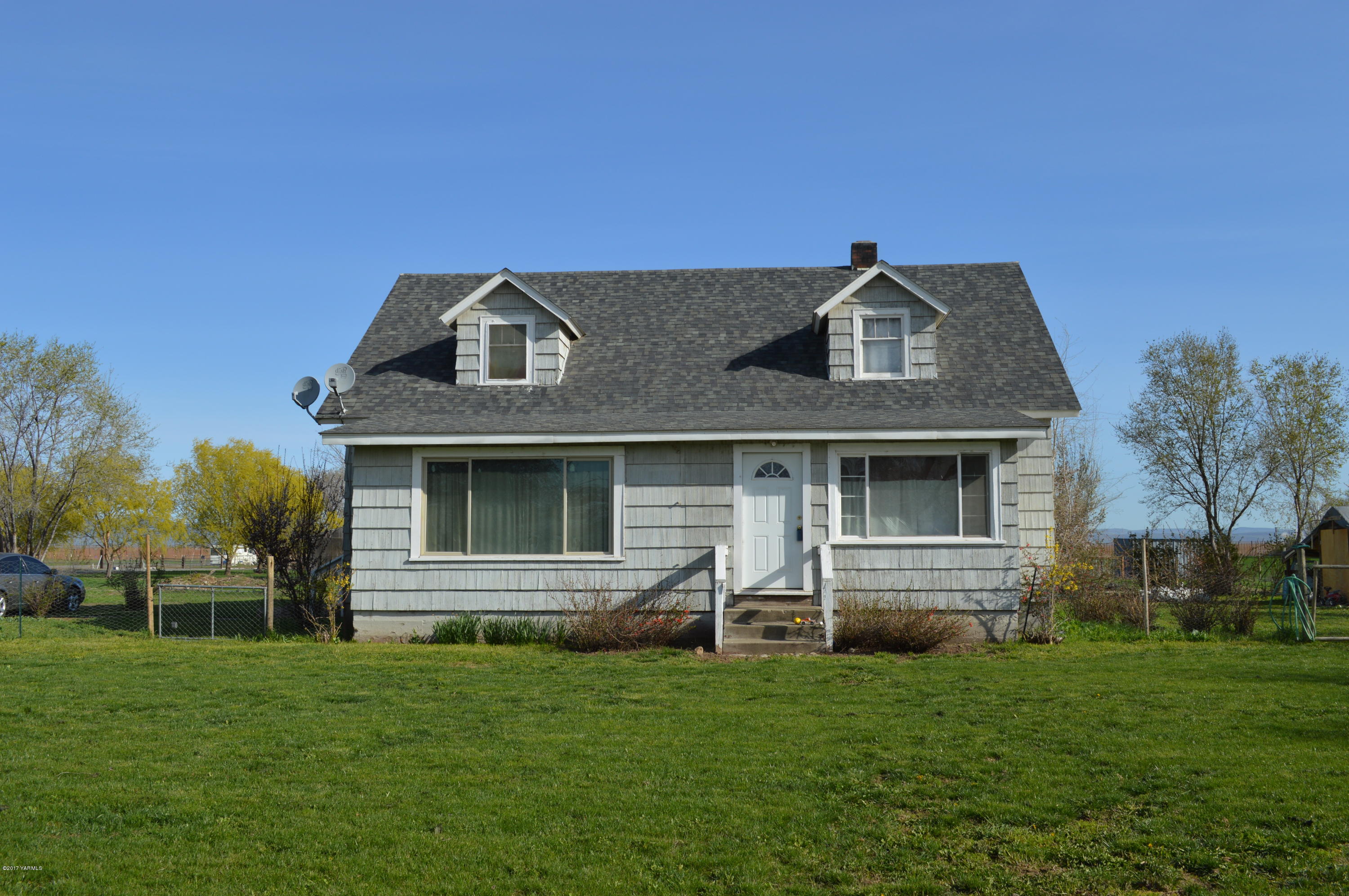 6941 McDonald Road Wapato, WA 98951 - Photo 2 of 24 a front view of a house with a garden