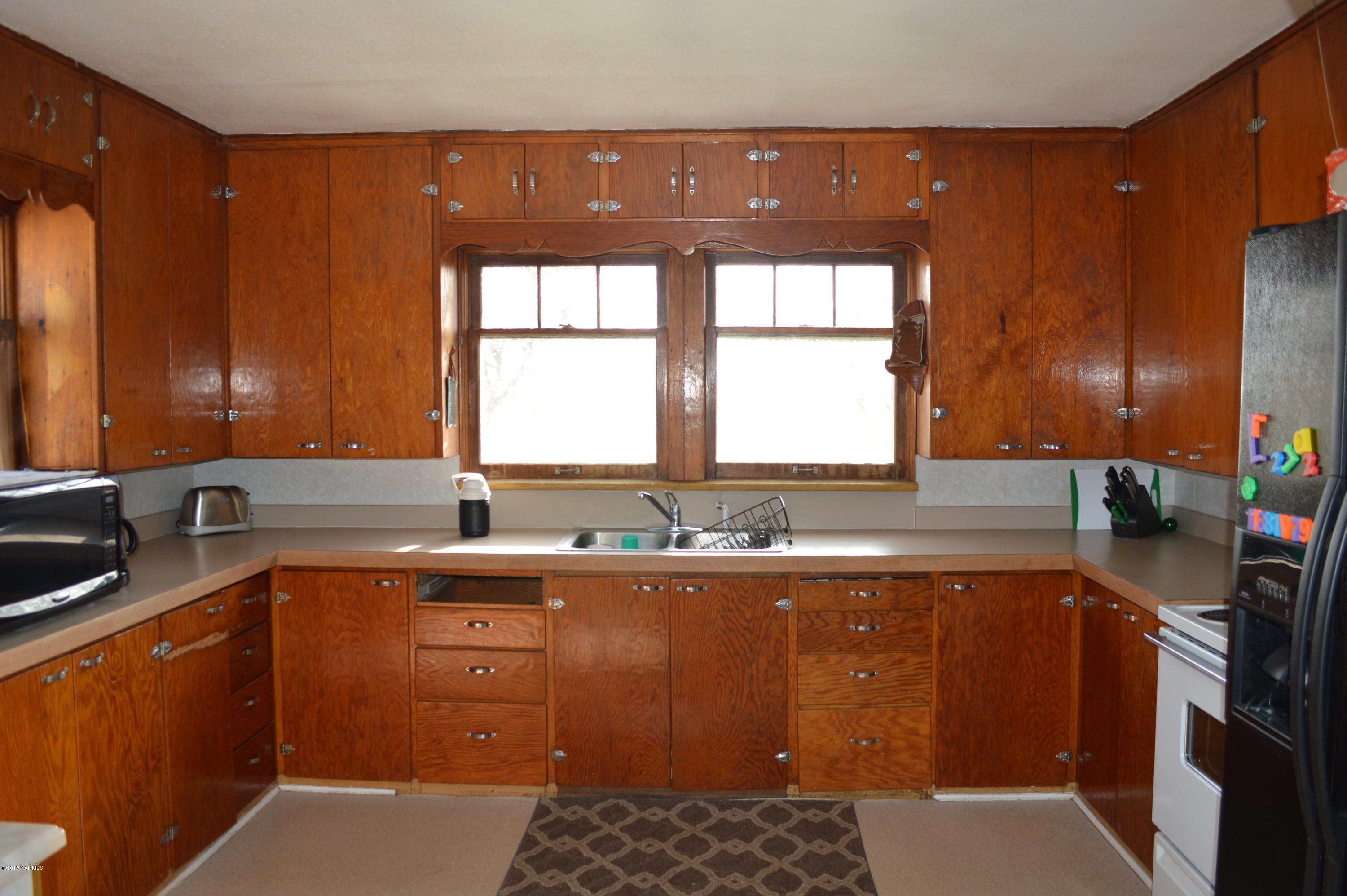6941 McDonald Road Wapato, WA 98951 - Photo 14 of 24 a kitchen with a sink a counter top space and cabinets