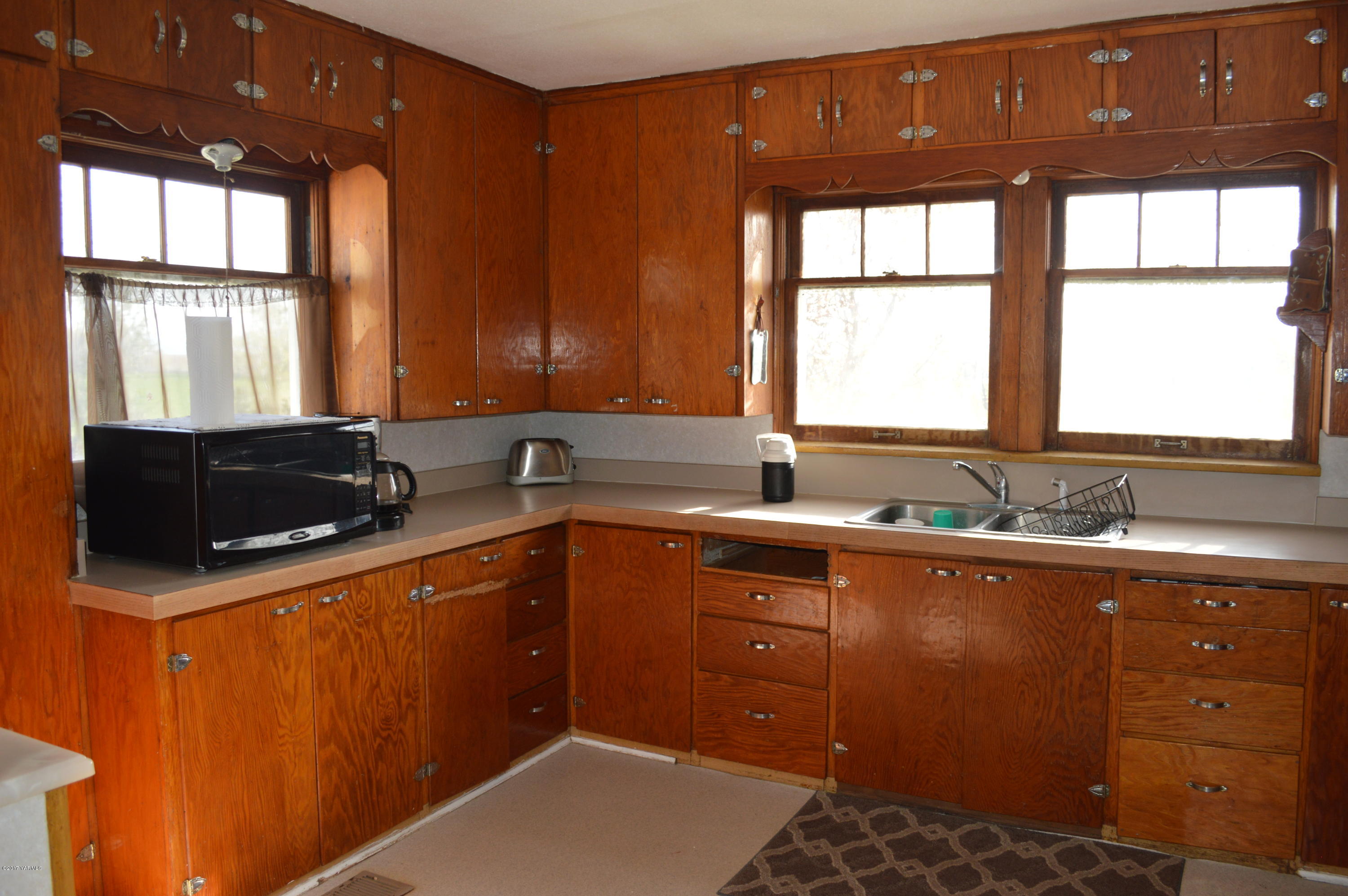 6941 McDonald Road Wapato, WA 98951 - Photo 15 of 24 a kitchen with stainless steel appliances kitchen island granite countertop a sink window and cabinets