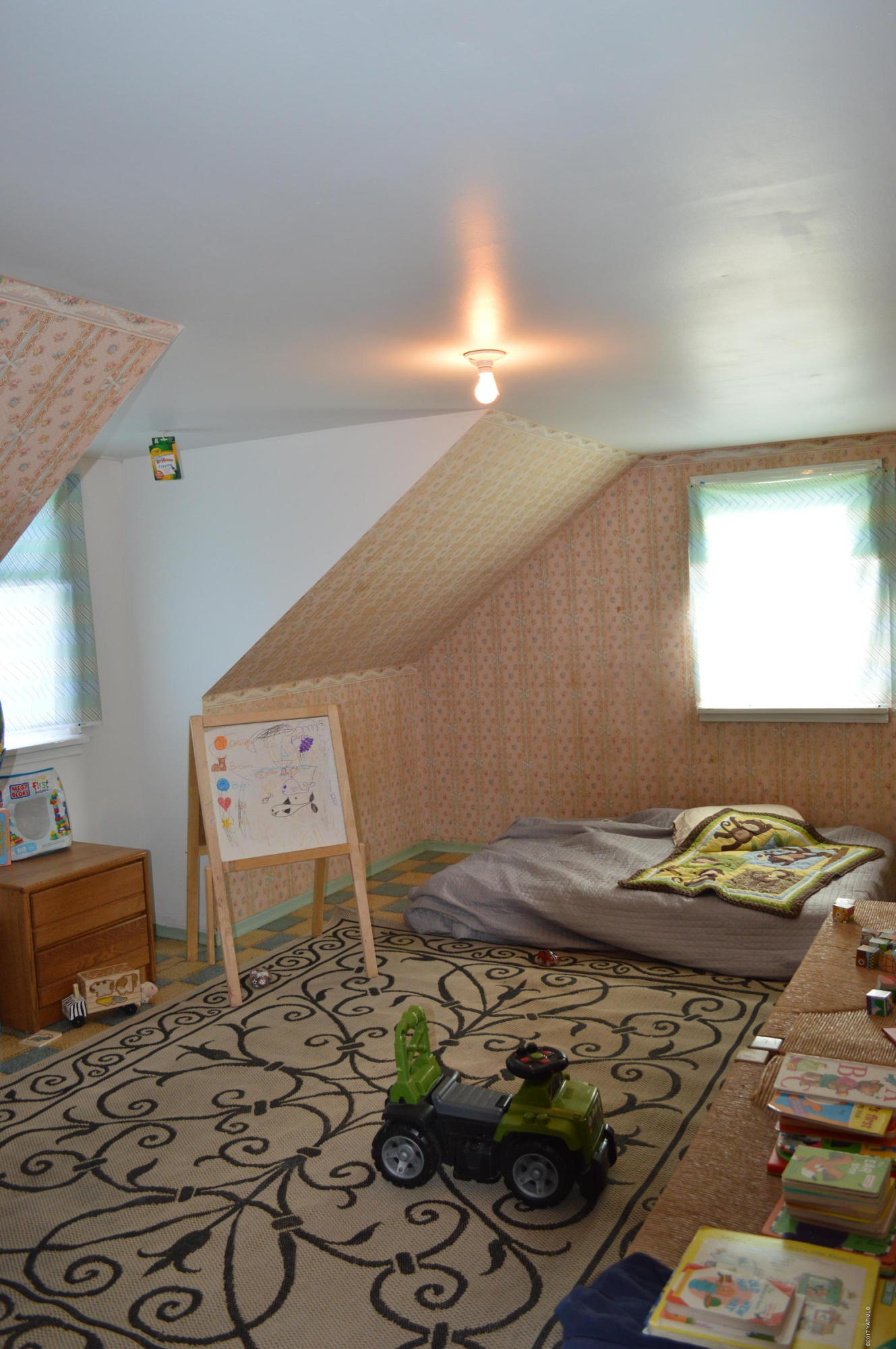 6941 McDonald Road Wapato, WA 98951 - Photo 19 of 24 a bed sitting in a bedroom next to a window