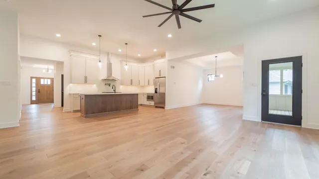 a view of an empty room with a window and wooden floor