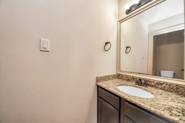 a bathroom with a toilet a sink and mirror
