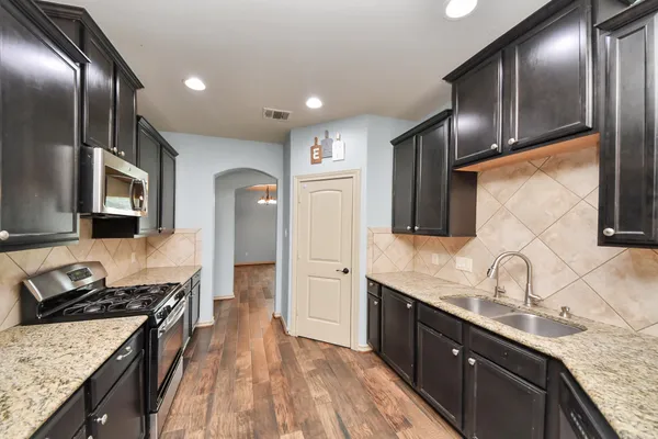 a bathroom with a granite countertop sink a toilet a mirror and shower