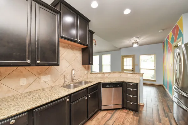 a bathroom with a granite countertop sink a toilet and shower