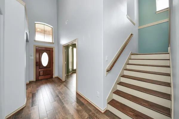 a view of an empty room with window and wooden floor