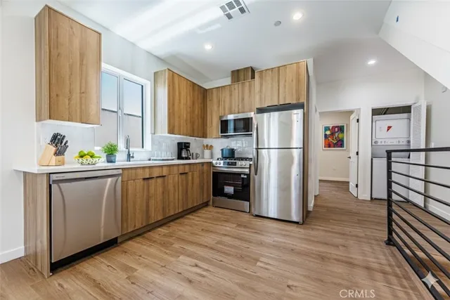 a kitchen with a refrigerator cabinets and wooden floor