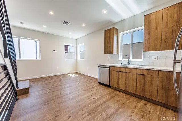 a view of a kitchen with cabinets stainless steel appliances and wooden floor