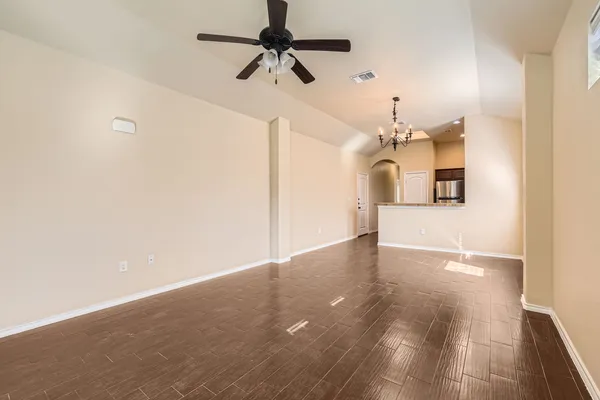 a view of a big room with a chandelier fan and windows