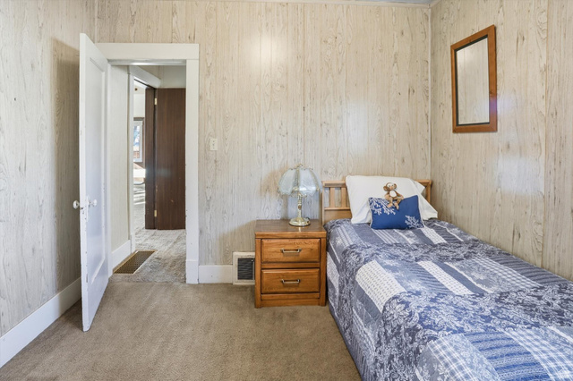 380 North 200 West Logan, UT 84321 - Photo 13 of 29 Carpeted bedroom with baseboards and light wood paneling.