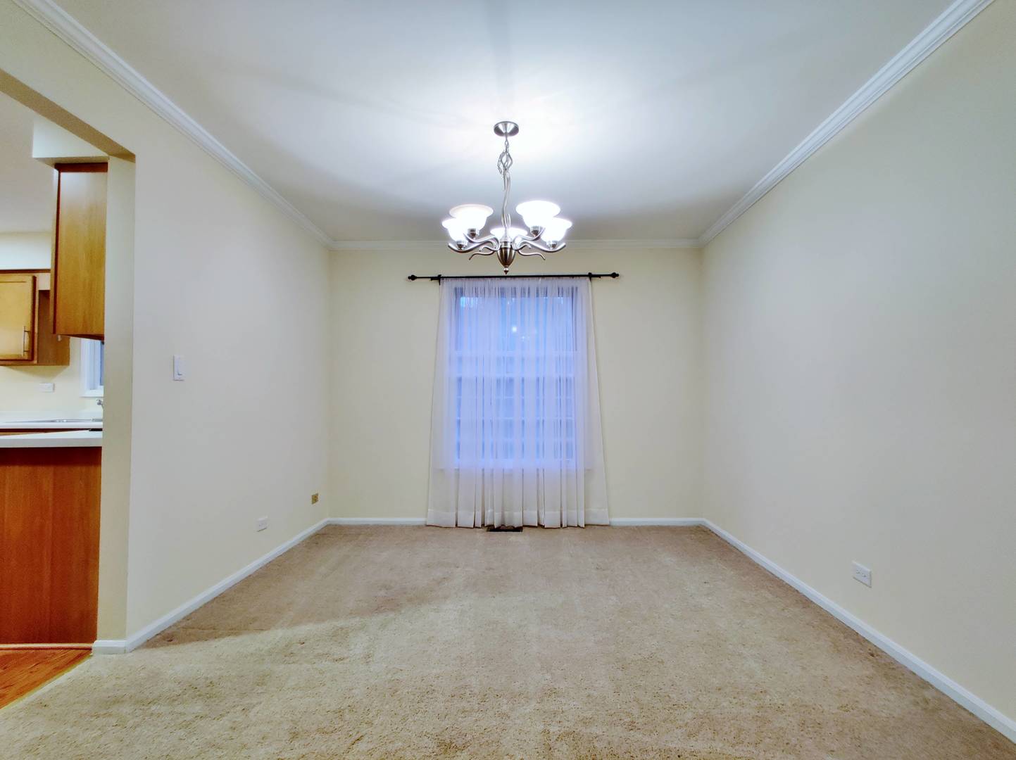 1520 Chippewa Drive Naperville, IL 60563 - Photo 3 of 18 an empty room with a chandelier fan and wooden floor
