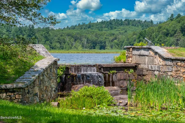 a front view of a house with a yard and a garden