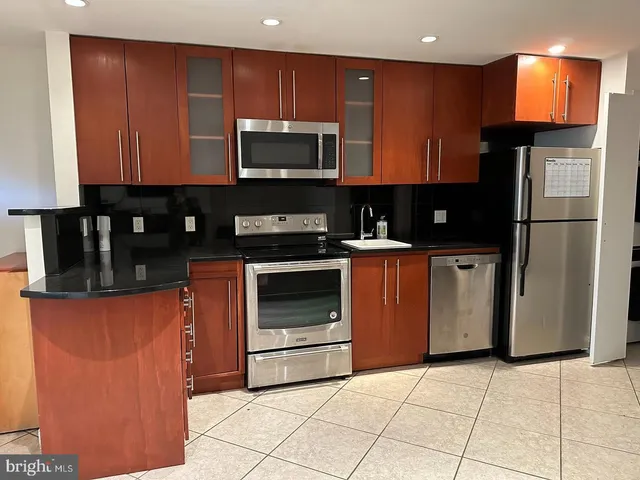 a kitchen with stainless steel appliances granite countertop a stove a microwave and a refrigerator