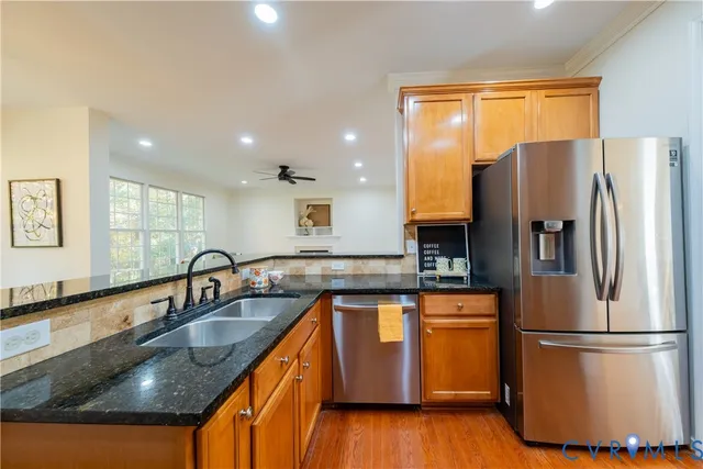 a kitchen with granite countertop a refrigerator and a sink