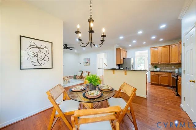 a view of a dining room with furniture a kitchen and wooden floor