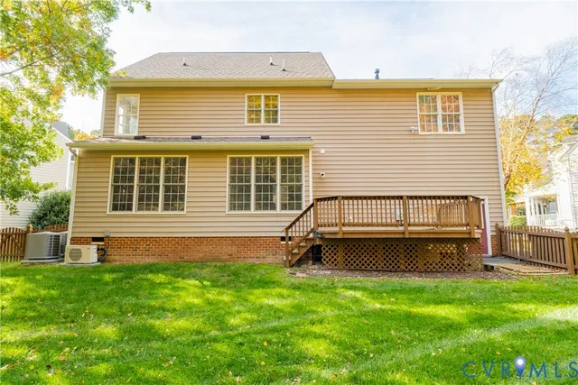 a backyard of a house with wooden deck and furniture