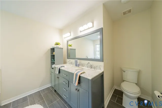 a bathroom with a sink mirror vanity and toilet