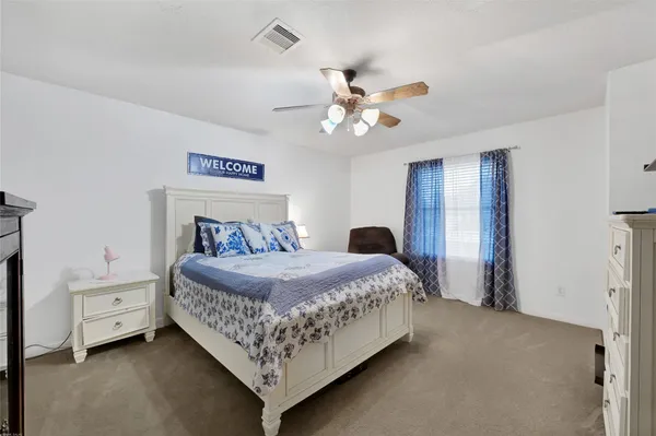 a bedroom with a bed chandelier and a window