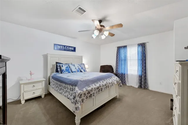 a bedroom with a bed chandelier and a window