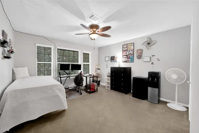 a bedroom with a large bed and a flat tv screen on dresser
