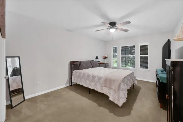 a spacious bedroom with a bed and a chandelier