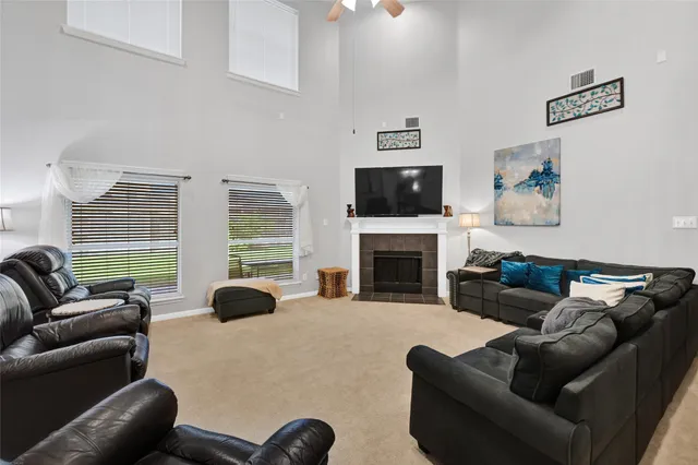 a living room with furniture a fireplace and a flat screen tv