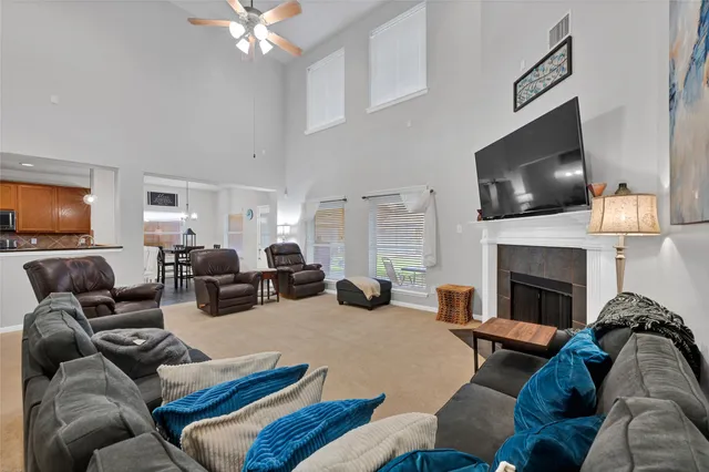 a living room with furniture a flat screen tv and a fireplace