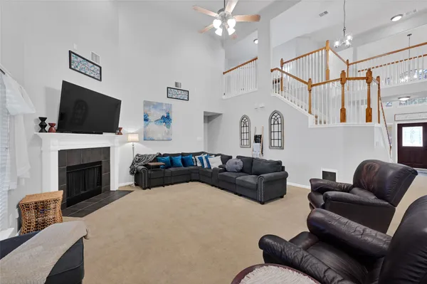 a living room with furniture a flat screen tv and a fireplace
